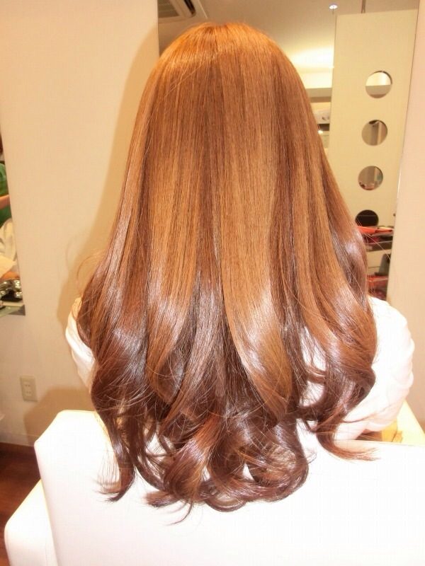 毛先をゆるく巻いたロングヘアの後ろ姿